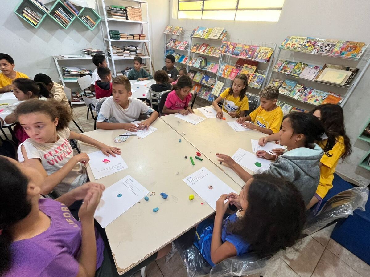 Crianças em atividade com massinha de modelar na biblioteca do SEPIN