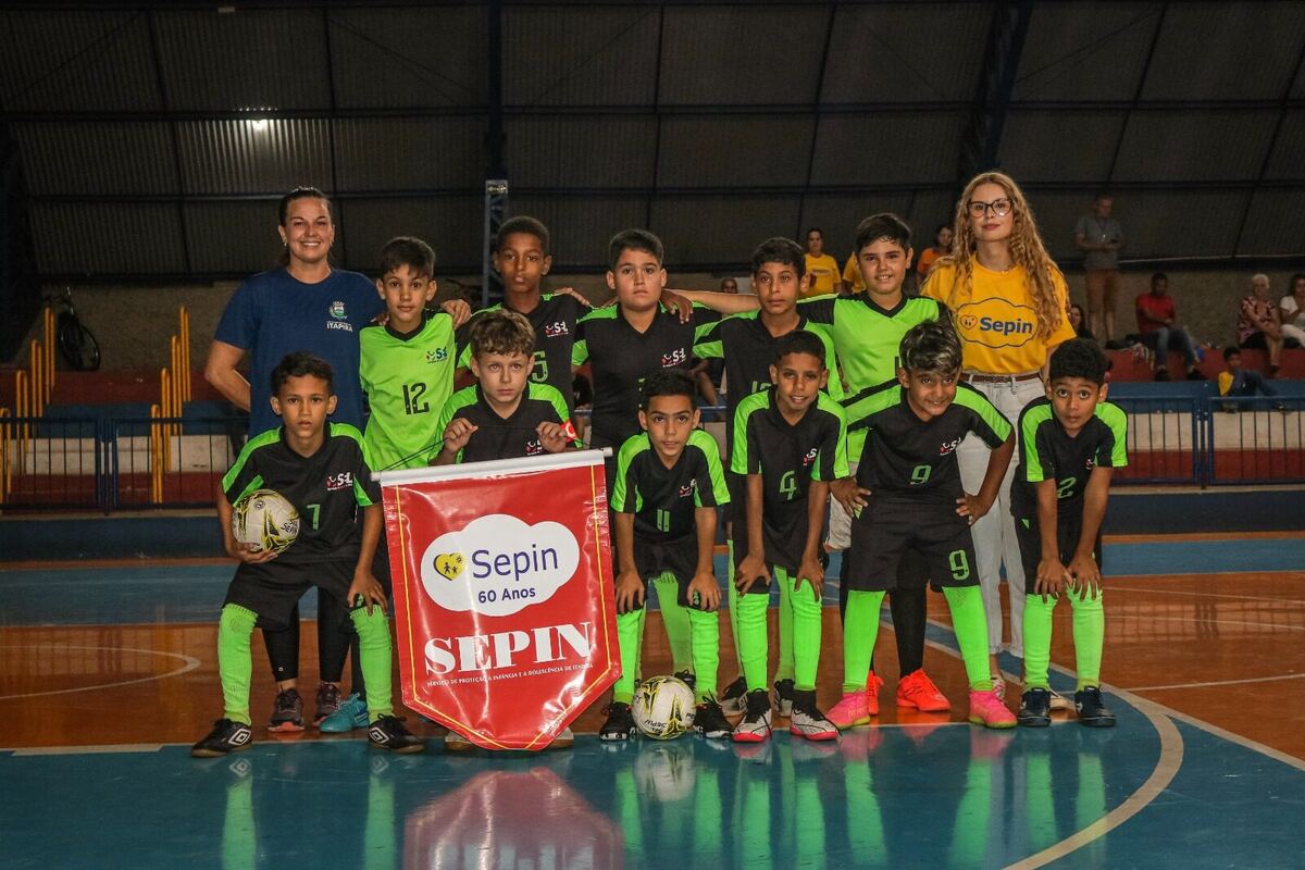 Time de futsal do SEPIN posando com bandeirola Sepin 60 Anos