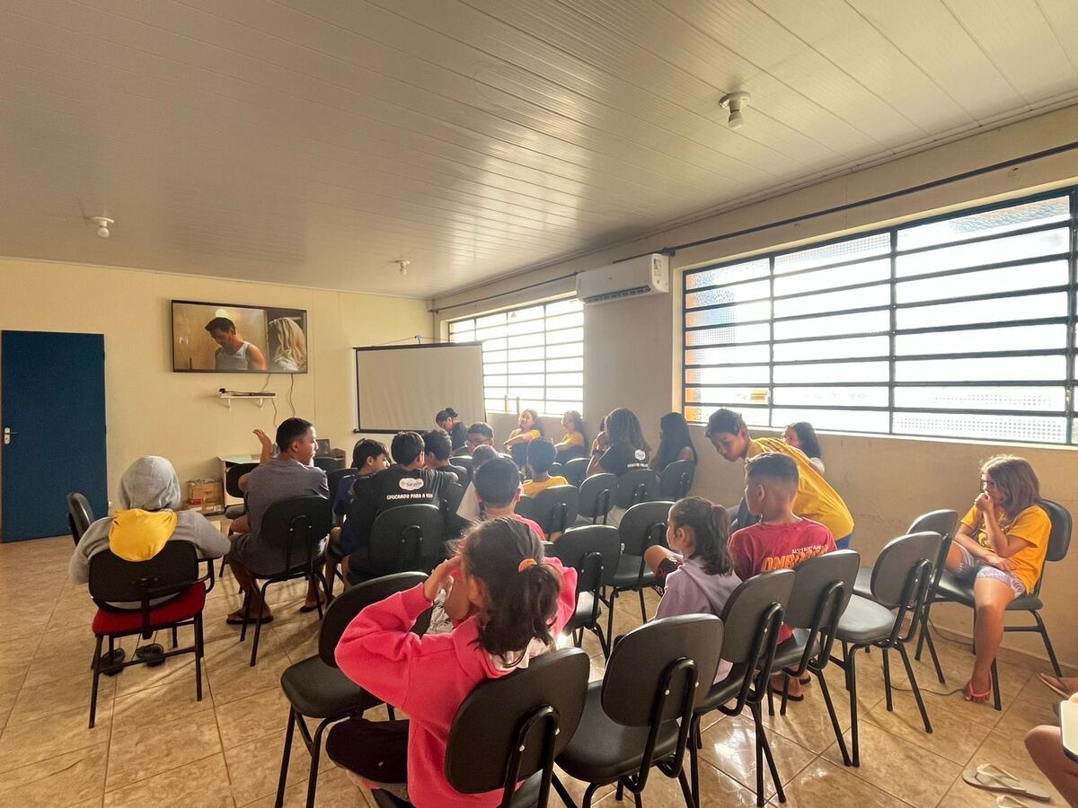 Crianças assistindo apresentação em sala de multimídia do SEPIN